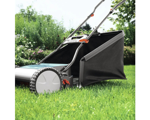 Ruční sekačka na trávu s košem na trávu na zahradě