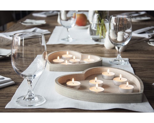 Dekorace stolu se svíčkami v držácích ve tvaru srdce a sklenicemi na víno