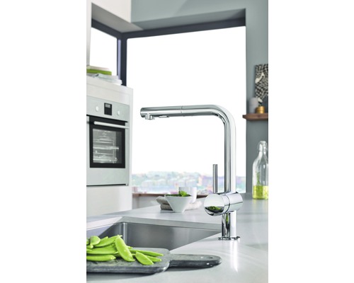 Kuchyňská scéna s dřezem, baterií a zeleninou na prkénku