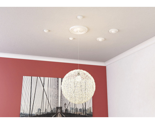 Stropní rozeta s ozdobnými lištami a závěsnou lampou v místnosti