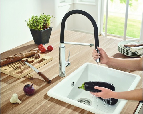 Kuchyňský dřez s výsuvnou baterií a zeleninou v dřezu