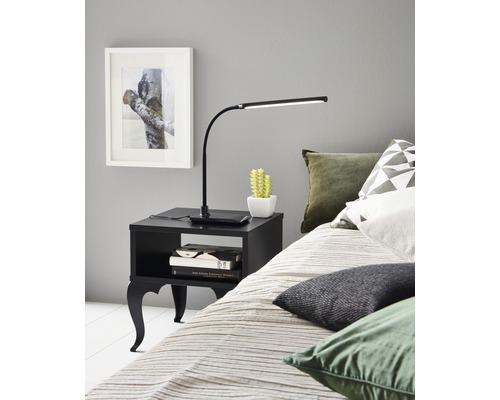 Ložnice s postelí, nočním stolkem a stolní lampou