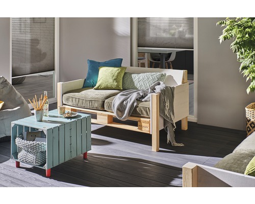 Obývací pokoj s paletovým nábytkem, který se skládá z pohovky, stolu a polštářů