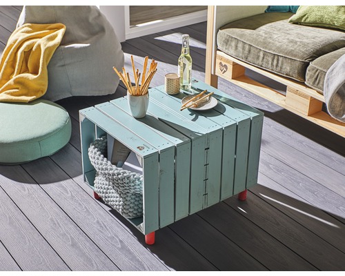 Obývací pokoj s stolem z dřevěných beden, sedacími vaky a pohovkou z palet