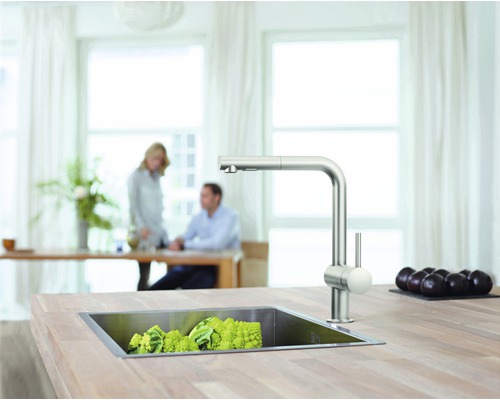 Kuchyňská scéna s dřezem, baterií a zeleninou na pracovní desce