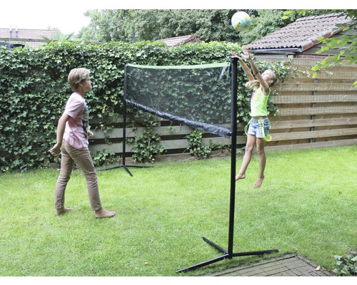 Dvě děti si hrají se sítí na zahradě.