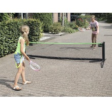 Dvě děti hrají venku s přenosnou tenisovou sítí.