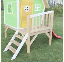 Hrací domek se schody a skluzavkou na zahradě.
