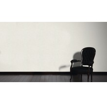 Dekorativní scéna s křeslem před stěnou na dřevěné podlaze