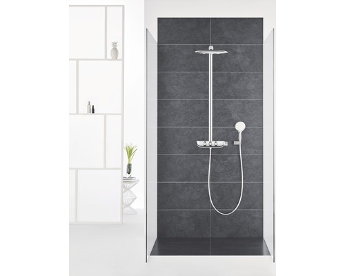 Sprchový kout s hlavovou a ruční sprchou a úložným prostorem pro sprchové potřeby na tmavém obkládaném pozadí