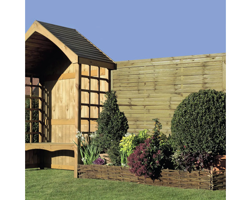 Zahradní krajina s dřevěným plotem, vrbovým záhonem a dřevěnou chatkou