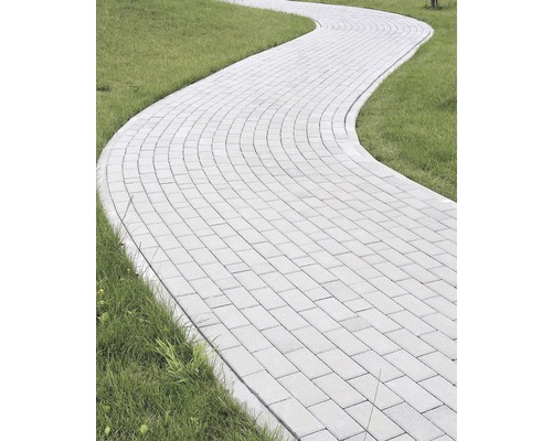 Zakřivená cesta z dlažebních kostek v zahradě