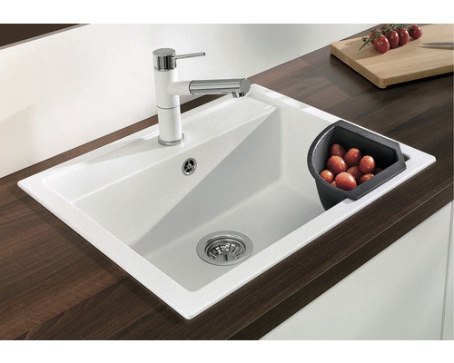 Dřez s vodovodní baterií a odkapávací miskou na pracovní desce.