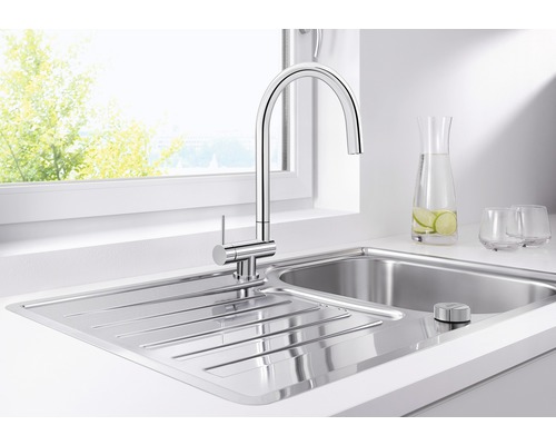 Nerezový kuchyňský dřez s baterií před oknem