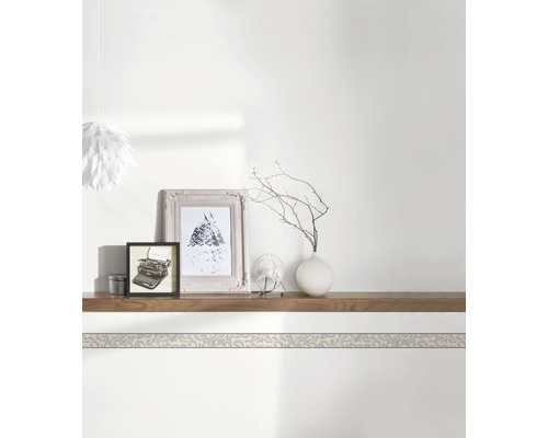 Ozdobná bordura na stěně nad policí s dekoracemi