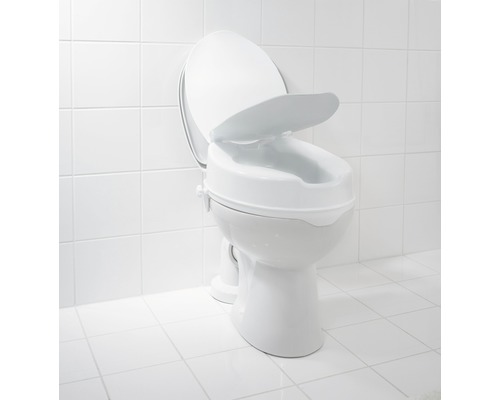 Zvýšené WC sedátko na toaletě v koupelně.