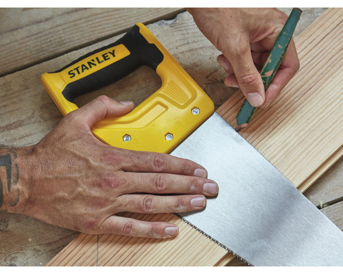 Řemeslník označuje dřevěnou desku tužkou a pilou