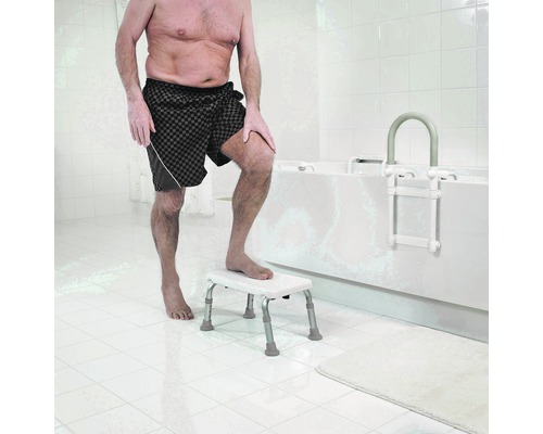 Muž používá koupelnovou stoličku a koupelnový žebřík v koupelně.