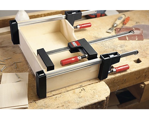 Dřevěná bedna upevněná svorkami na pracovní lavici