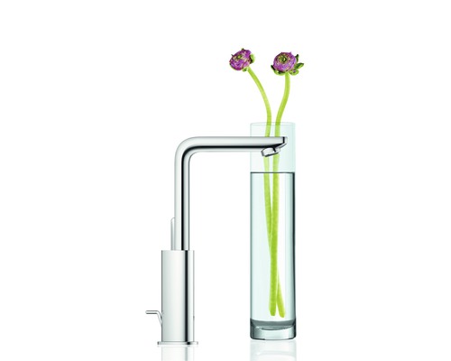 Chromová umyvadlová baterie vedle sklenice s květinami