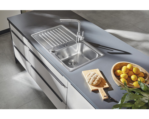 Nerezový dřez s odkapávací plochou a baterií na kuchyňské lince