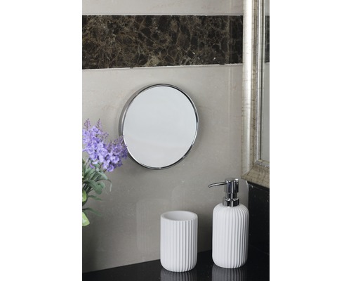 Koupelnová scéna s kulatým zrcadlem, kelímkem na zubní kartáčky a dávkovačem mýdla