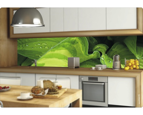 Kuchyňská scéna s kuchyňskou deskou s motivem rostlin, kuchyňským náčiním a potravinami na pracovní desce.