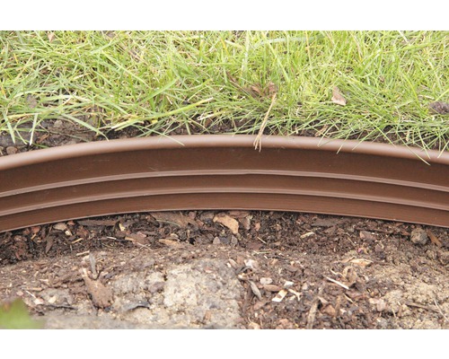 Zahradní scéna s trávníkem a hnědým plastovým obrubníkem