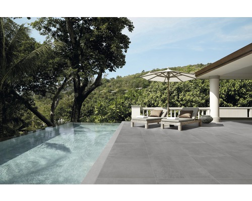 Exteriér s šedou dlažbou, bazénem a lehátky