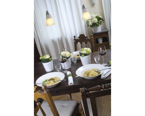 Prostřený jídelní stůl s těstovinami, nápoji, květinami a lampami