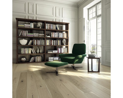 Světlý obývací pokoj s knihovnou, křeslem, podnožkou a dřevěnou podlahou