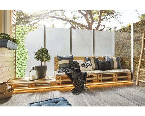 Terasa s paletovým nábytkem, polštáři, rostlinami a zástěnou