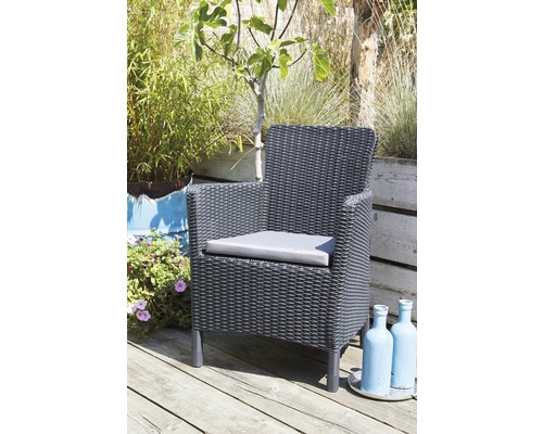 Zahradní nábytek: proutěné křeslo s polštářem na dřevěné terase