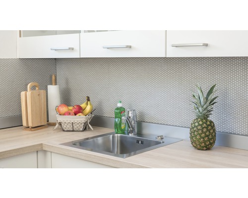 Kuchyňská scéna s dřezem, vodovodní baterií, prkénky, papírovou utěrkou, košíkem ovoce a ananasem