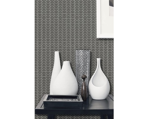 Dekorativní obývací pokoj s tapetou se vzorem, různými vázami a obdélníkovým podnosem na stole.