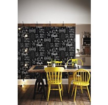 Pohled do místnosti s tapetou se vzorem tabule, jídelním stolem a žlutými židlemi