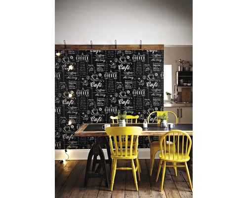 Pohled do místnosti s tapetou se vzorem tabule, jídelním stolem a žlutými židlemi