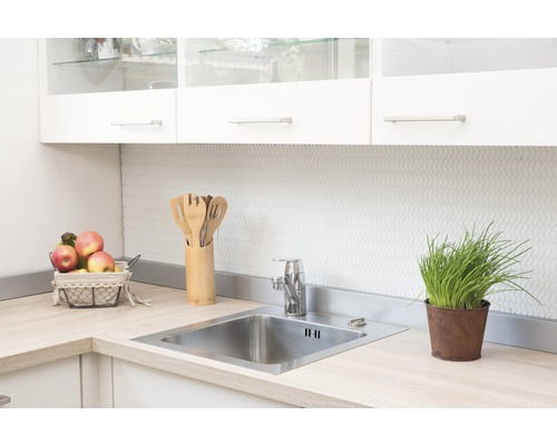 Kuchyňský dřez s baterií a pomůckami na světlé pracovní desce