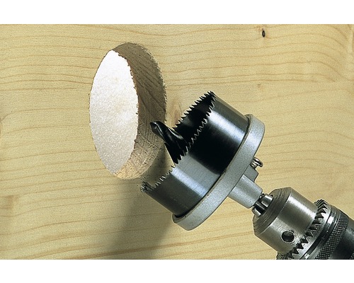 Děrovací pila vrtá otvor do dřevěné desky