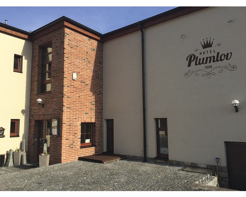 Vnější pohled na hotel s fasádou z kamene a omítky