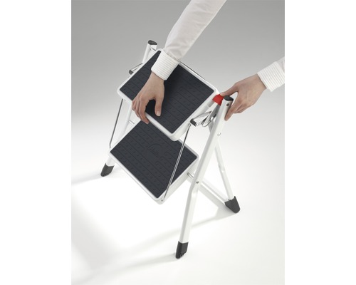 Osoba rozkládá dvoustupňový žebřík pro domácnost.