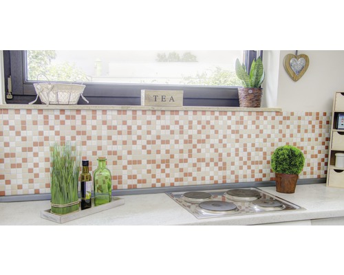 Kuchyňská scéna s mozaikovými obklady, dekorací a varnou deskou.