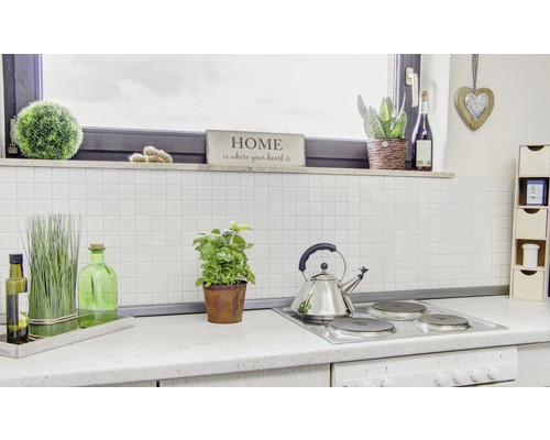 Kuchyňská scéna s varnou deskou, čajovou konvicí, bylinkami a dekoracemi