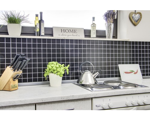 Kuchyňská scéna s obkladem, varnou deskou, konvicí a různým kuchyňským náčiním