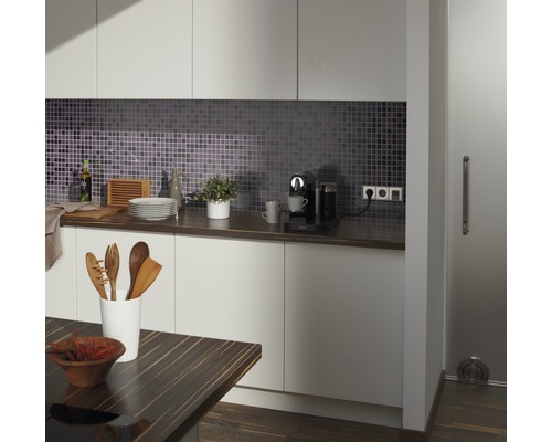 Moderní kuchyně s mozaikovými obklady, pracovní deskou, kuchyňskými potřebami a kávovarem.