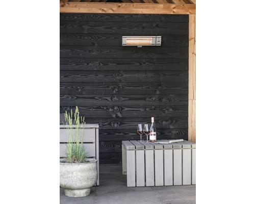 Terasa s infračerveným ohřívačem, dřevěnou stěnou, stolem, lahví vína a sklenicemi