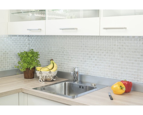 Kuchyňská scéna s dřezem, vodovodní baterií, mozaikovými dlaždicemi a potravinami