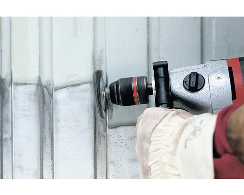 Osoba používá drátěný kartáč na vrtačce k úpravě povrchu.