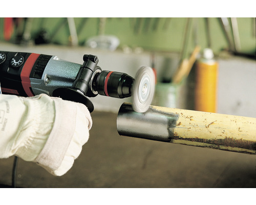 Vrtačka s drátěným kartáčem se používá k čištění kovové trubky.