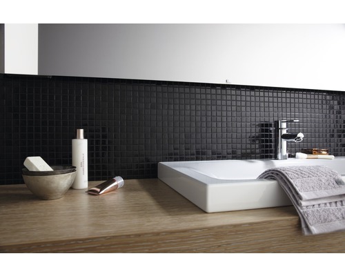 Moderní koupelna s umyvadlem na desku, baterií, ručníkem a mozaikovými obklady